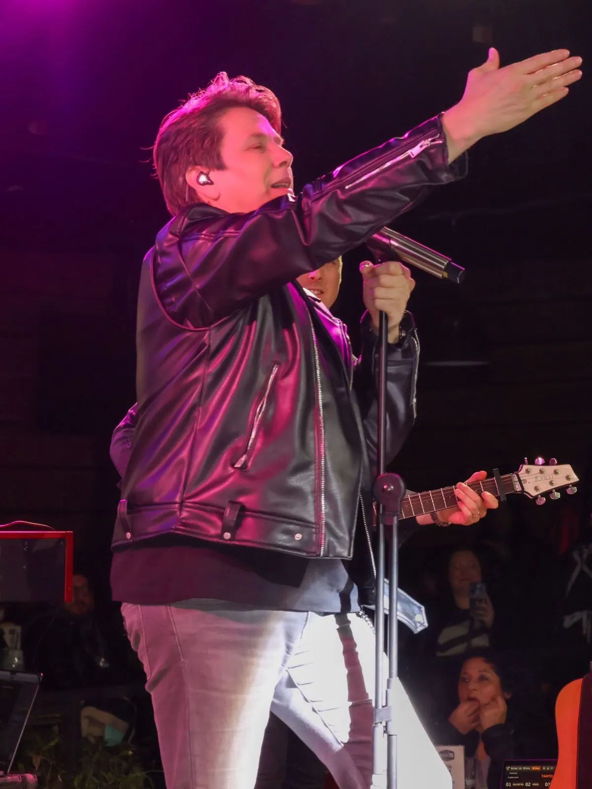Cantante con chaqueta de cuero en el escenario de Ruta 78, con luces moradas