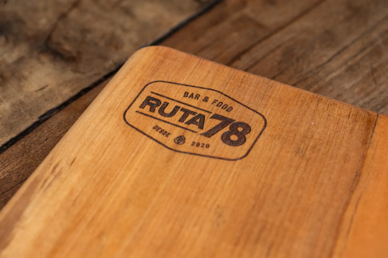 Tabla de madera con el logo de Ruta 78 grabado